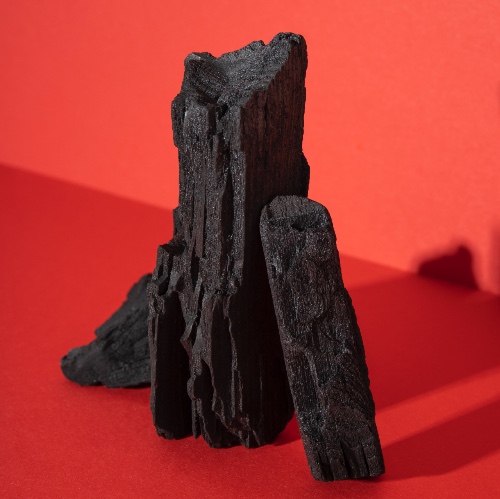 pieces of charcoal set against a red background